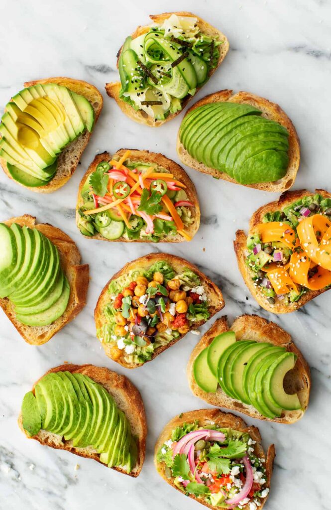 Healthy breakfast recipes - Avocado toast with fresh tomatoes and greens on a plane